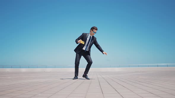 Flexible and cool businessman doing acrobatic tricks outdoor