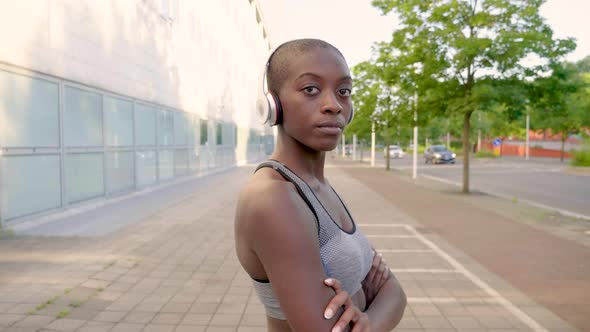 Slow motion shot of young athletic woman with headphones in city