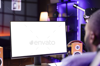 Man in RGB illuminated home using enjoying game on mockup computer monitor