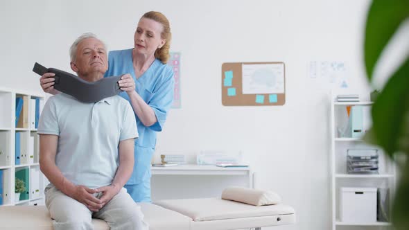 Female Physiotherapist Putting Bandage on Patient Neck