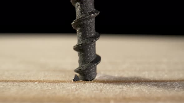 The Screw Gun Screwed Black Selftapping Screws Into a Wooden Board on Black Background