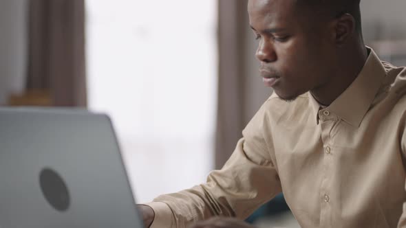 Black Male Student is Working with Laptop Sending Message in Social Nets or in Work Chat Portrait