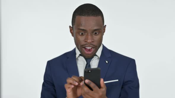 African Businessman Cheering Success on Smartphone White Background