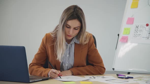 Young Businesswoman Writing on Paper