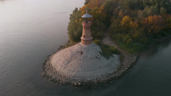 Amazing revealing drone footage of the old stone lighthouse by the Danube river. Beautiful autumn co