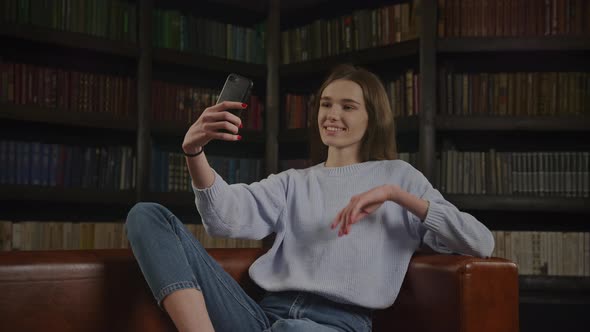 Young Adult Caucasian Woman Student Taking Selfie on Her Smart Phone Indoors in Slow Motion