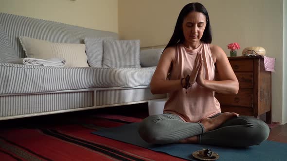 Woman using singing bowl with wooden striker behind window