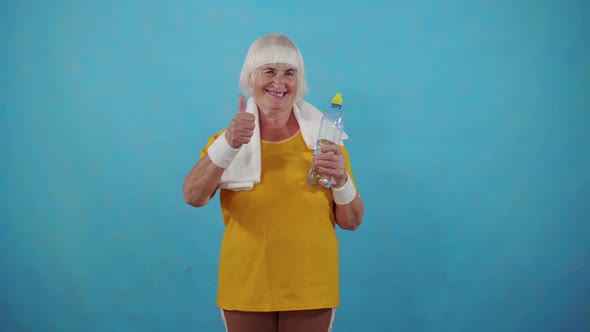 Active Positive Sports Old Woman Water Bottle Showing Thumb Up Blue Background