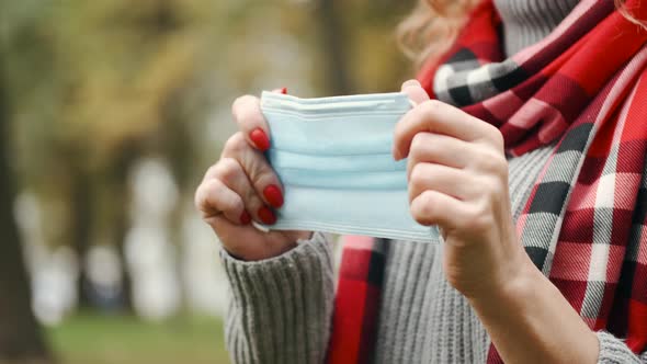 Woman Put on Protective Mask in a Park