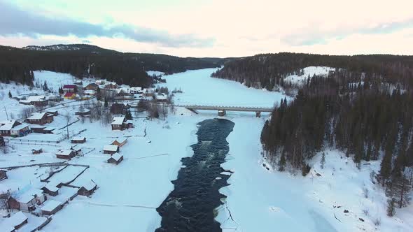 Snow, village and river under the ice