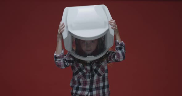 Girl Putting on Oversized Helmet