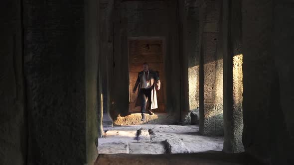 Man Coming Out of a Narrow Passageway Entrance and Sprints Out of Frame