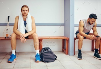 Portrait of a caucasian athlete sitting in a locker room. Two men sitting in a gym locker room toge