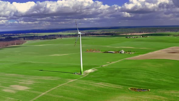 Wind turbine on green field in spring, aerial view