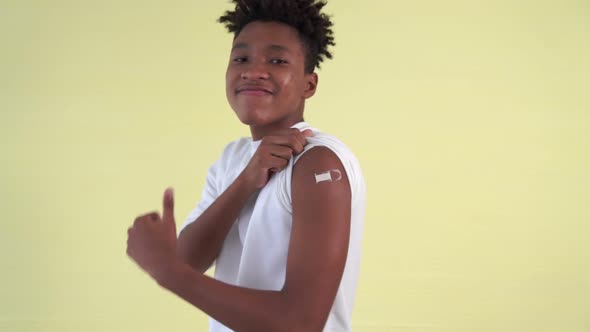 African American Teenager Showing COVID19 Vaccine Bandage Merrily