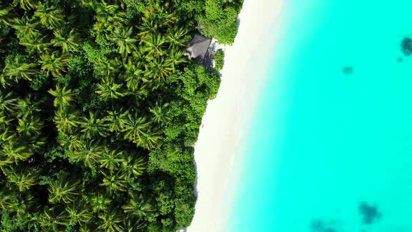 Aerial top down landscape of exotic island beach lifestyle by transparent lagoon with white sandy ba