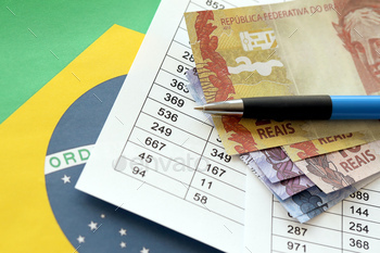 Pen with Brazilian money bills on blank of lottery game. Concept of luck and gambling in Brazil