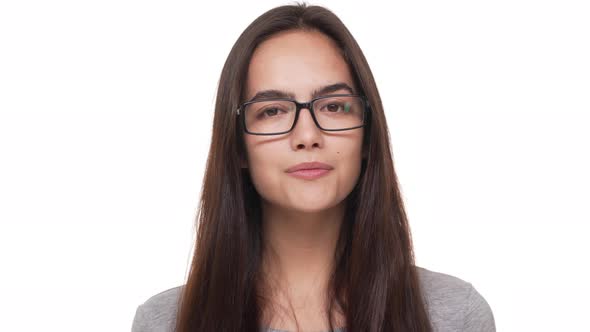 Portrait of Beautiful Young Lady with Long Dark Hair Wearing Glasses Looking at Camera Smiling