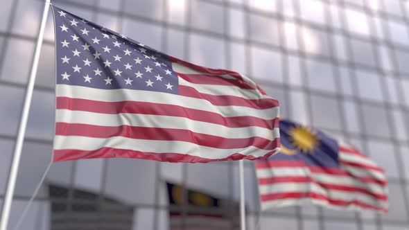 Flags of the United States and Malaysia in Front of a Skyscraper