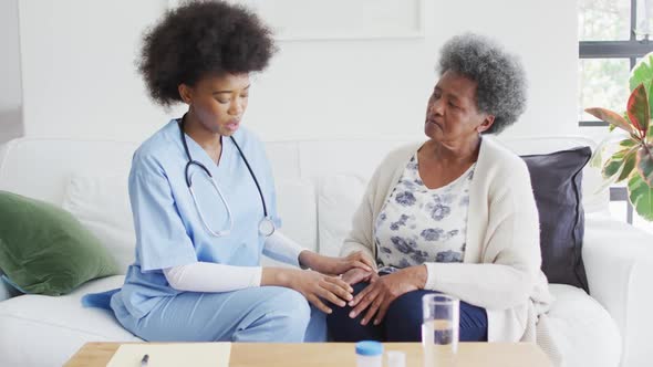 Unhappy african american female doctor and sad senior female talking