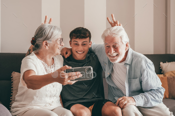 Video call. Multigenerational family of grandparents and grandson video calling with cellphone