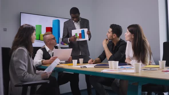 Portrait of Expert African American Man Presenting Business Strategy Idea with Colleagues Endorsing