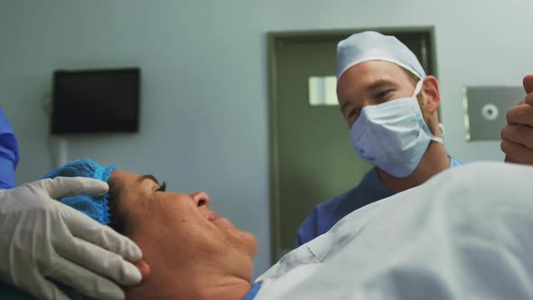 Front view of Caucasian man comforting pregnant woman during labor in operation theater at hospital