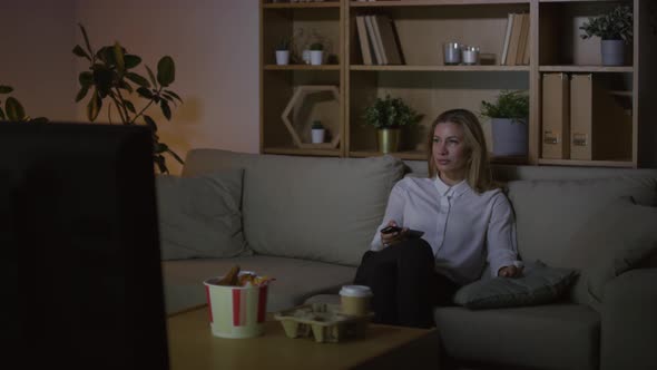 Businesswoman Watching TV at Home in Evening