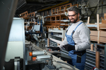 Specialist with working documentation at the console of modern machine