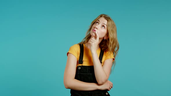 Thinking Woman Looking Up and Around on Blue Background. Pensive Face Expressions. Pretty Model with