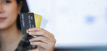 Female holding credit card. Beautiful smiling showing credit card to online payment.