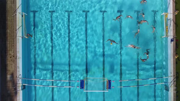 Aerial Drone Top View Shot of People Competing in Water Polo in Turquoise Water Pool