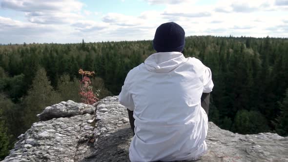 Man Sitting On The Top Of The High Rock
