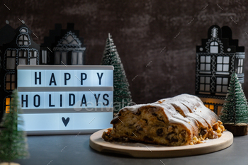 Lightbox with text HAPPY HOLIDAYS. Homemade Christmas traditional cake pie with marzipan nuts and