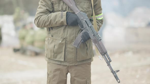 Closeup of Unrecognizable Soldier Reloading Army Gun Outdoors