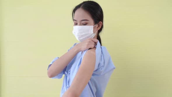 Young Asian Woman Showing COVID19 Vaccine Bandage Merrily