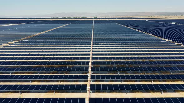 Drone Is Flying Straight Forward Above the Graphic Rows of Solar Power Fields alt