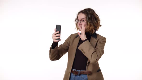 Charming Trendy Young Woman with Curly Short Hair Having Video Chat Through Phone and Laughing