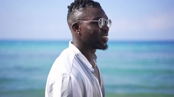 Side View of Smiling African American Handsome Man in Sunglasses with Turquoise Blue Mediterranean