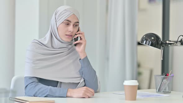 Arab Woman Angry While Talking on Smartphone in Office