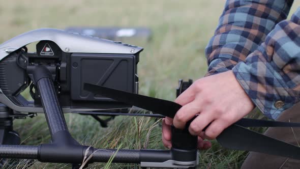 Man Pilot Checking Quadcopter Drone Before Aerial Flight and Filming