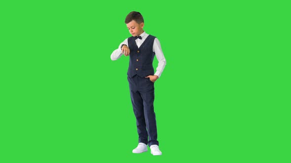 Schoolboy in Waistcoat and Bow Tie Checking His Watch Rolling Eyes and Sighing on a Green Screen
