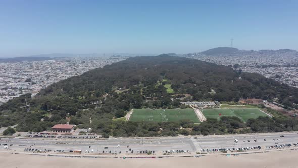 Super wide reverse pullback aerial shot of Golden Gate Park from the Pacific Ocean in San Francisco.