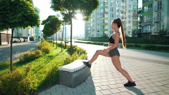 Fitnesswoman Stretching Legs on Bench in City