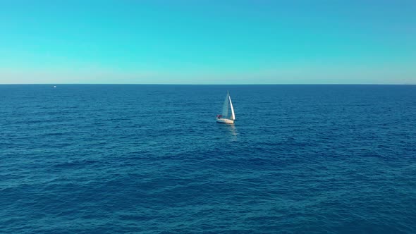 Aerial View. Yacht Sailing on Opened Sea. Yachting with Sails Up at Windy Day.