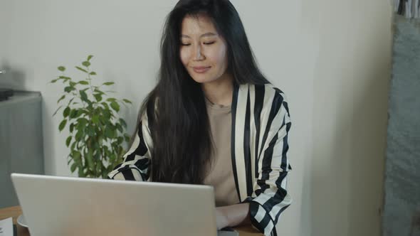 Successful Freelancer Asian Lady Using Laptop Computer Working at Home in Kitchen