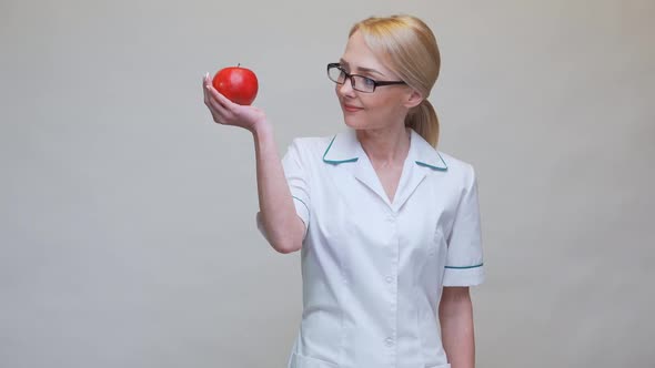Nutritionist Doctor Healthy Lifestyle Concept - Holding Organic Red Apple and Measuring Tape
