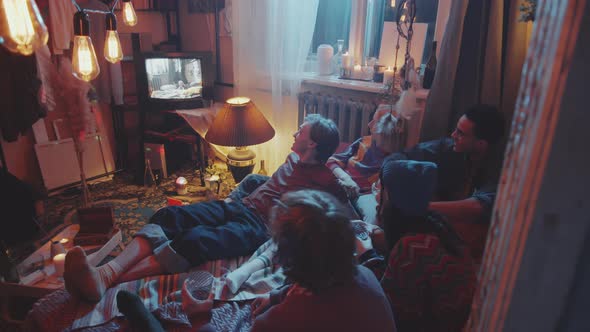 Young Friends Watching VHS Video on Retro TV at Home