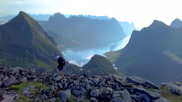 Girl with a Backpack Rises on a Mountain Ridge