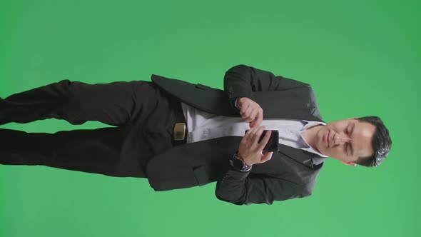 Asian Business Man Use Mobile Phone While Walking On Green Screen Chroma Key